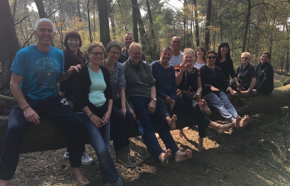 Eine Gruppe von Teilnehmenden ruht sich im Wald aus